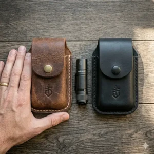 A compact leather gerber multi tool pouch held in hand to demonstrate its slim profile and size.