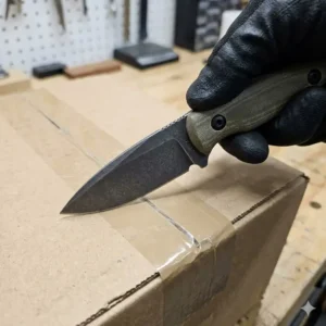An everyday carry fixed blade knife being used for a common utility task like opening a package.